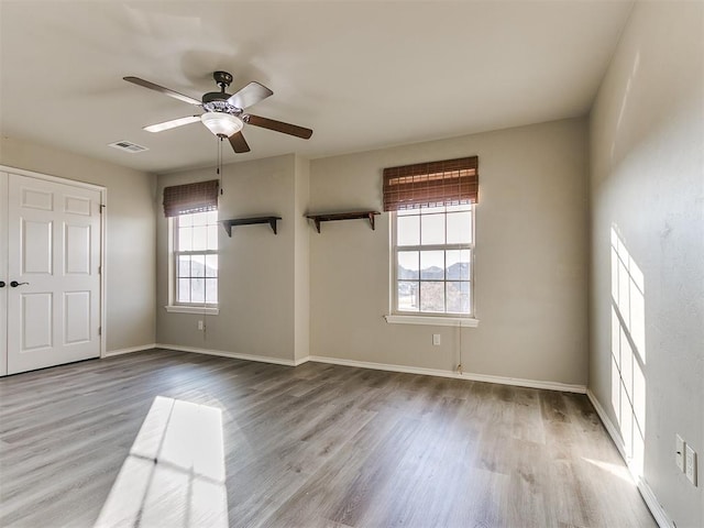 spare room with light wood-type flooring and plenty of natural light