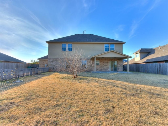 rear view of property featuring a patio area and a yard