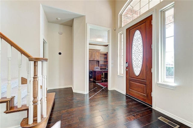 entryway featuring dark wood-type flooring and a high ceiling