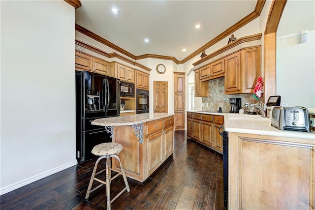 kitchen featuring a center island, black appliances, a kitchen breakfast bar, dark hardwood / wood-style floors, and ornamental molding