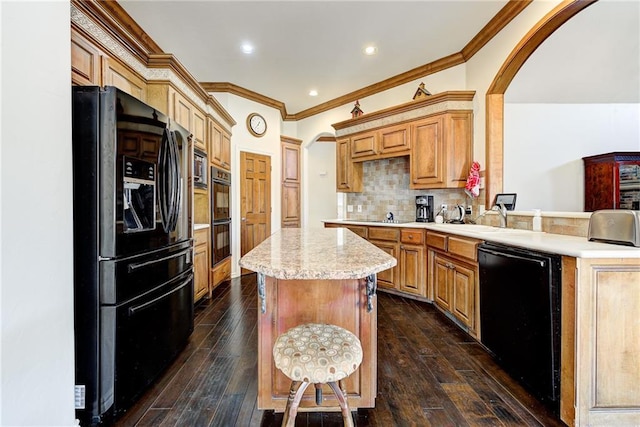 kitchen with tasteful backsplash, crown molding, dark wood-type flooring, black appliances, and a center island