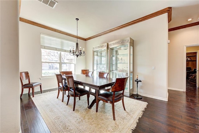 dining room with a notable chandelier, crown molding, and dark wood-type flooring