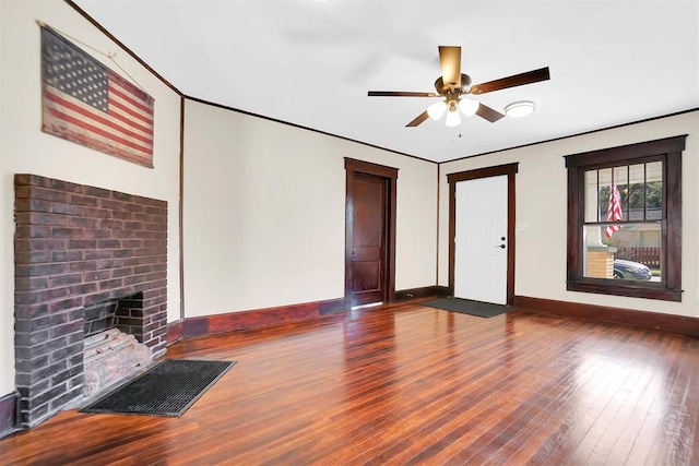 unfurnished living room featuring a fireplace, dark hardwood / wood-style flooring, and ceiling fan