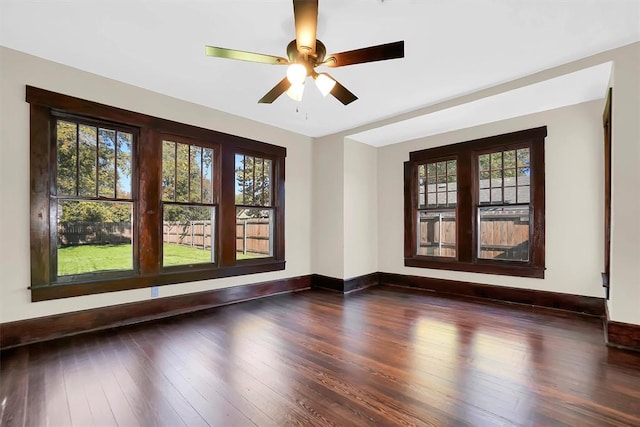 unfurnished room featuring dark hardwood / wood-style floors, ceiling fan, and a healthy amount of sunlight