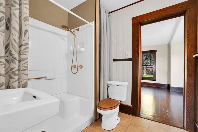 bathroom featuring toilet, wood-type flooring, and walk in shower