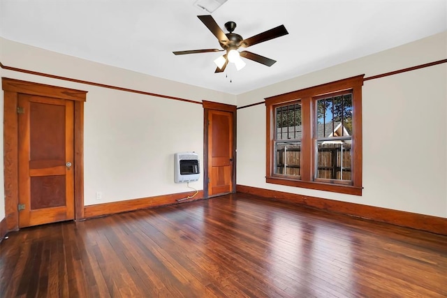 spare room featuring heating unit, ceiling fan, and dark hardwood / wood-style floors