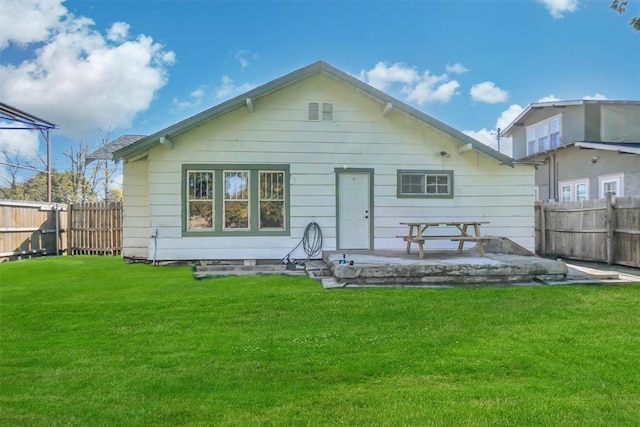 back of property with a yard and a patio area