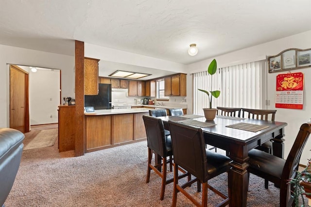 dining space featuring light carpet