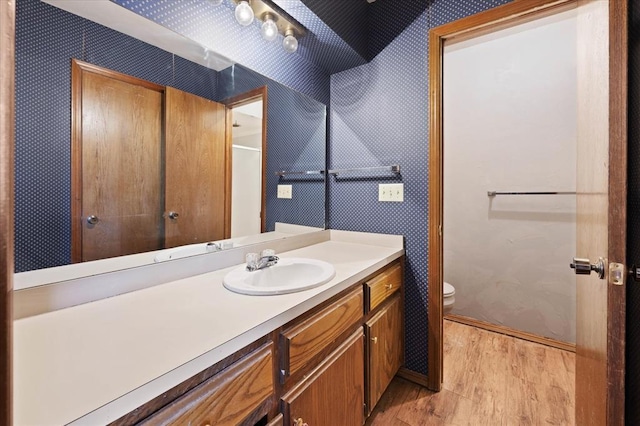 8207 NW 78th St Unit 2, Oklahoma City, OK 73132 - bathroom featuring wood finished floors, vanity, and wallpapered walls