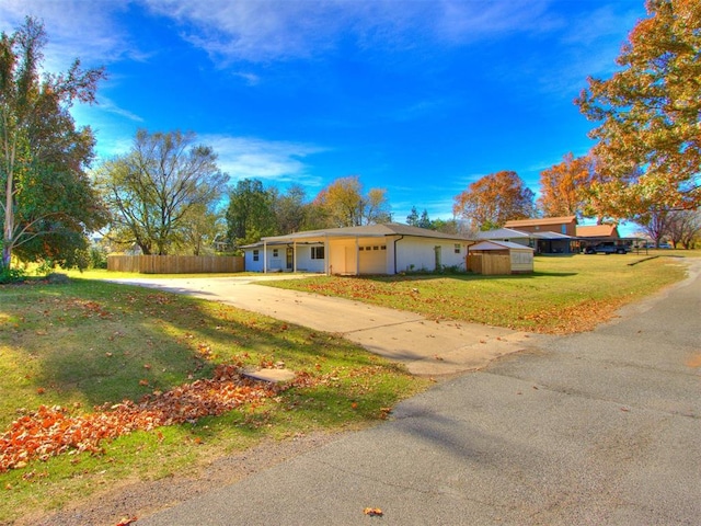 ranch-style home featuring a garage and a front lawn