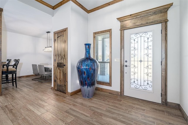 entryway with crown molding and light hardwood / wood-style flooring