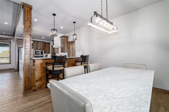 dining area featuring dark hardwood / wood-style flooring and decorative columns