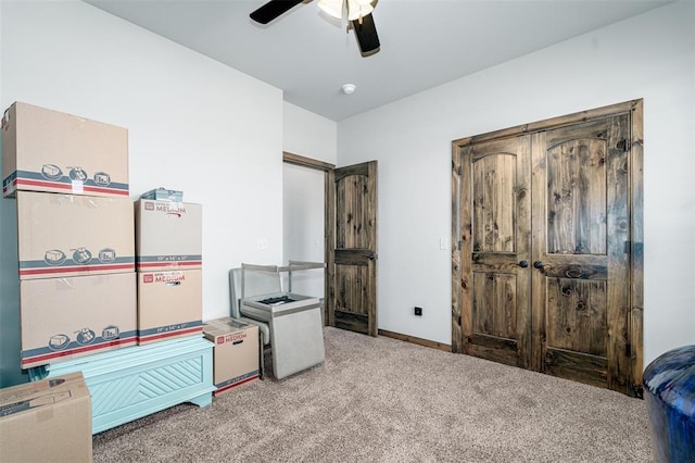 interior space featuring ceiling fan and carpet