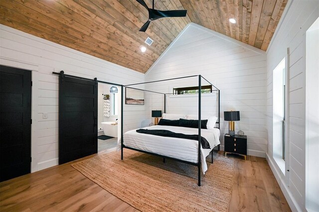 bedroom featuring hardwood / wood-style floors, ceiling fan, a barn door, and wooden ceiling