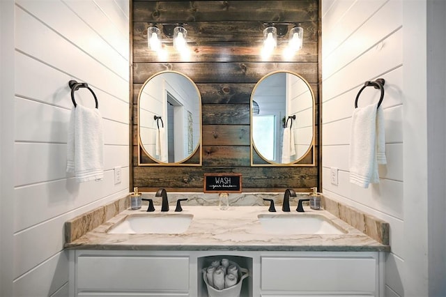 bathroom featuring vanity and wooden walls