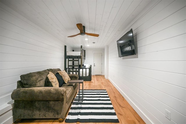 living room featuring wood walls, ceiling fan, light hardwood / wood-style floors, and wood ceiling