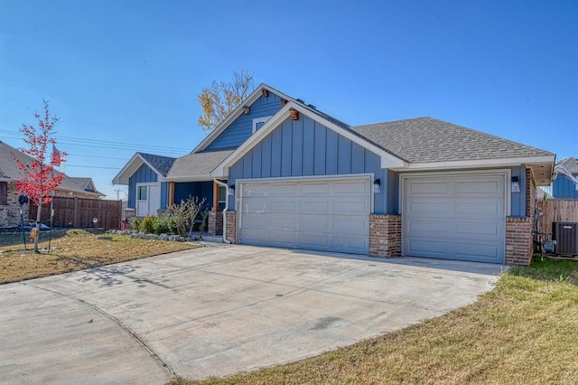 view of front of property with central AC unit, a front yard, and a garage