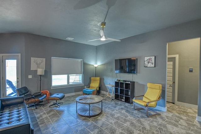 living room with visible vents, baseboards, and a ceiling fan