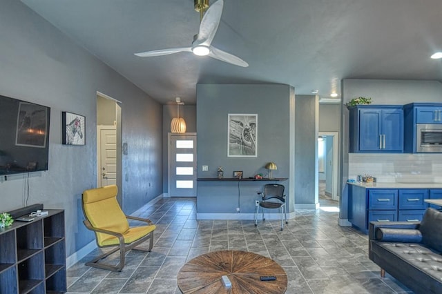 living room featuring a ceiling fan and baseboards