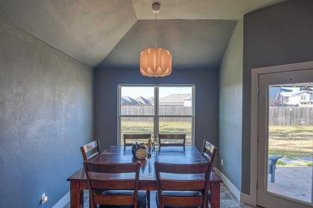 dining room featuring a healthy amount of sunlight and lofted ceiling