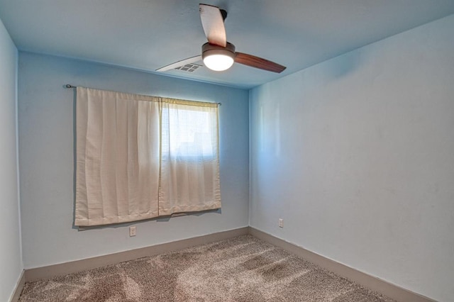 carpeted empty room with visible vents and a ceiling fan