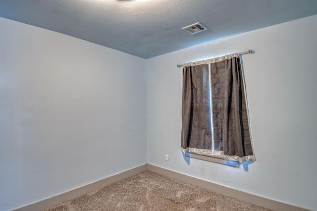 unfurnished room with carpet floors and visible vents