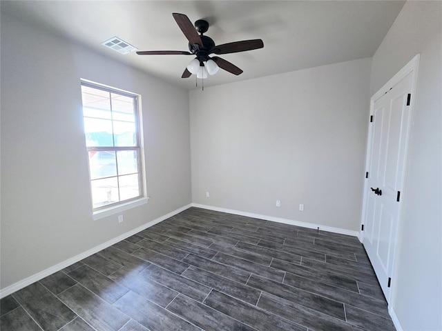 spare room with dark hardwood / wood-style floors and ceiling fan