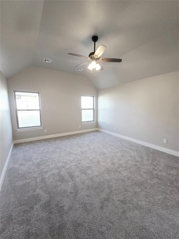 carpeted empty room featuring ceiling fan and lofted ceiling