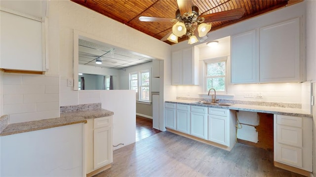 kitchen featuring light hardwood / wood-style flooring, white cabinetry, wooden ceiling, and sink