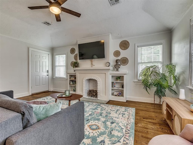 living room with dark wood-type flooring, crown molding, vaulted ceiling, ceiling fan, and a textured ceiling