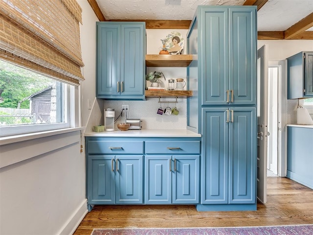 bar featuring hardwood / wood-style floors, blue cabinetry, and tasteful backsplash