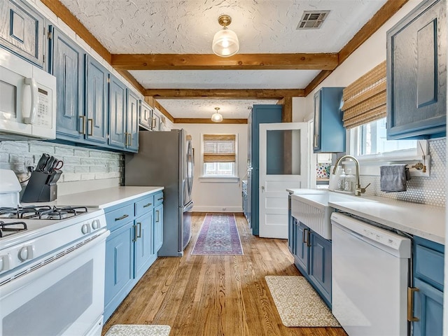 kitchen with backsplash, light hardwood / wood-style floors, white appliances, and blue cabinets