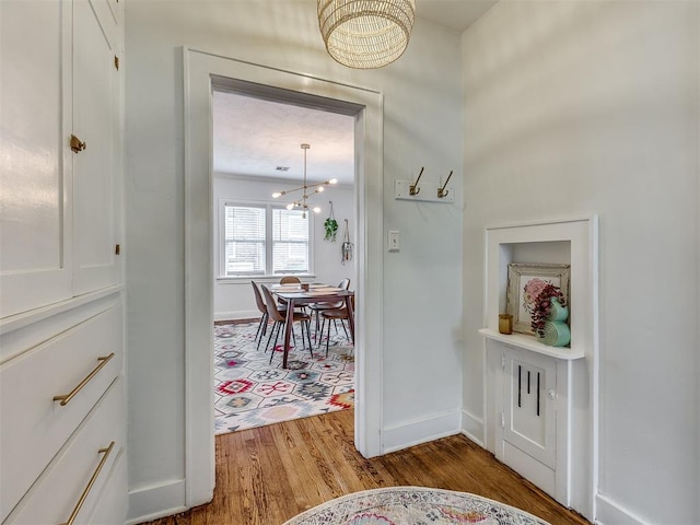 corridor featuring hardwood / wood-style floors and an inviting chandelier