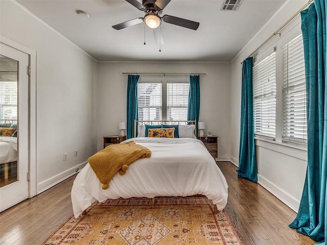 bedroom featuring multiple windows, ceiling fan, and wood-type flooring