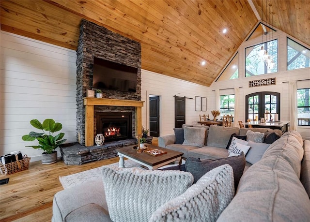 living room with french doors, beamed ceiling, high vaulted ceiling, a fireplace, and light wood-type flooring