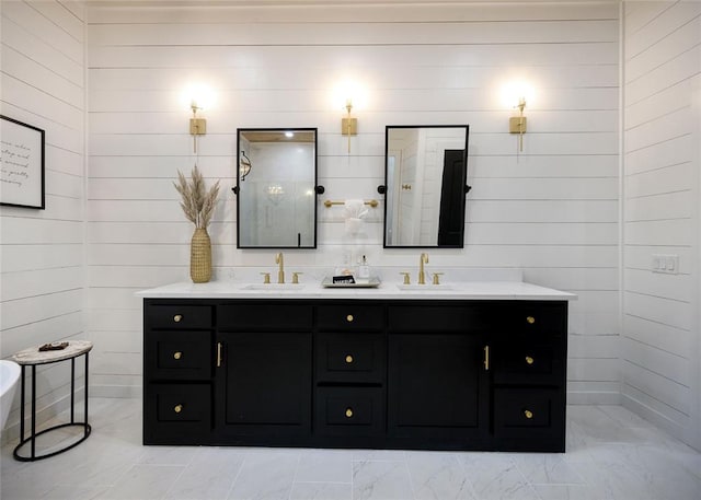 bathroom featuring vanity, wood walls, and walk in shower