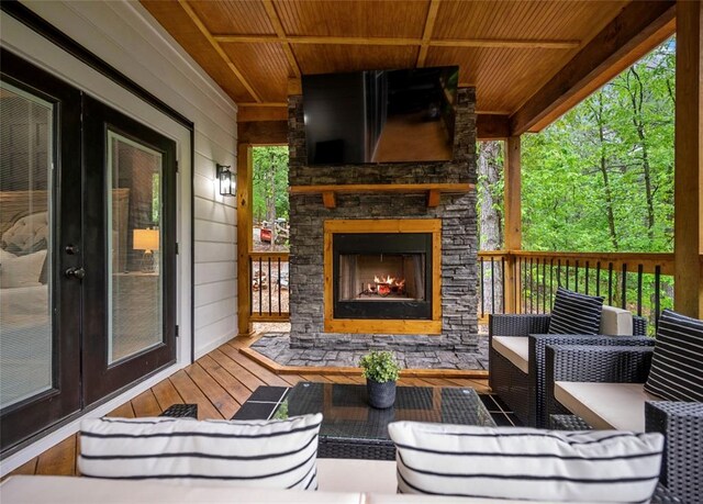 deck featuring an outdoor living space with a fireplace and french doors