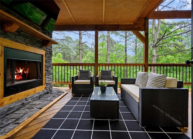 deck with an outdoor living space with a fireplace