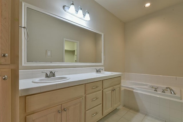 bathroom with vanity, tiled bath, and tile patterned floors