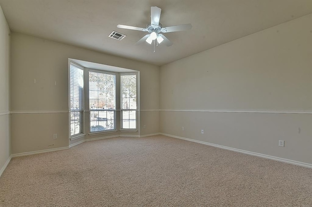 carpeted spare room featuring ceiling fan