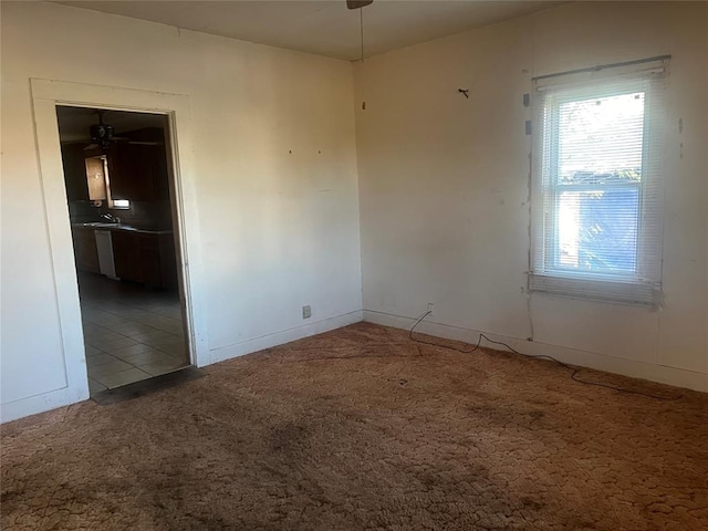 carpeted spare room featuring ceiling fan