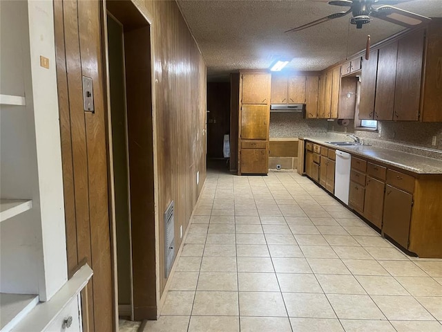 kitchen featuring white dishwasher, wooden walls, decorative backsplash, ceiling fan, and light tile patterned floors