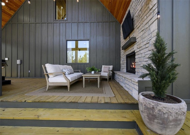 sitting room featuring an outdoor brick fireplace, wood-type flooring, wood ceiling, and high vaulted ceiling