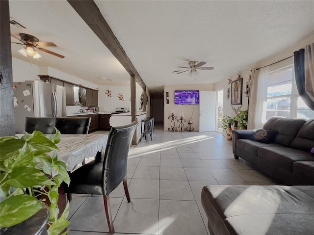 tiled living room with beam ceiling and ceiling fan