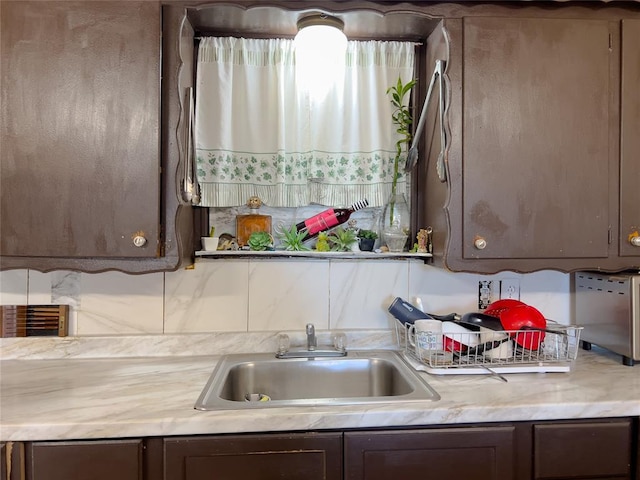 kitchen featuring dark brown cabinetry and sink