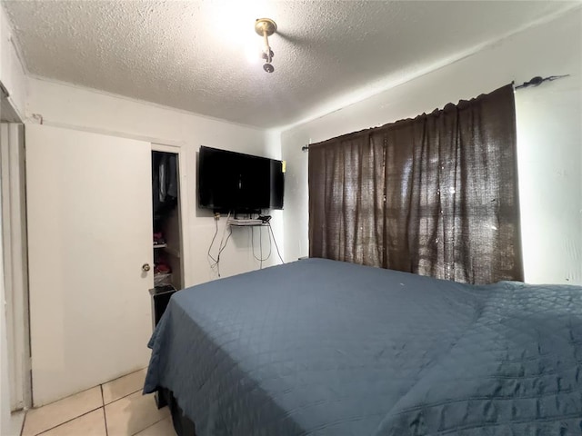 tiled bedroom featuring a textured ceiling