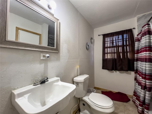 bathroom with tile patterned flooring, toilet, and sink