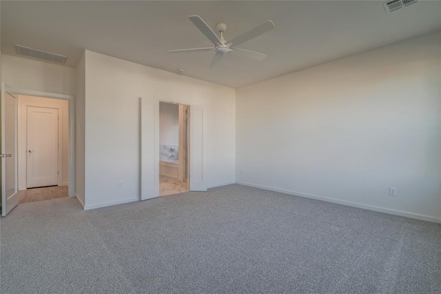 unfurnished bedroom featuring ceiling fan, light carpet, and ensuite bath