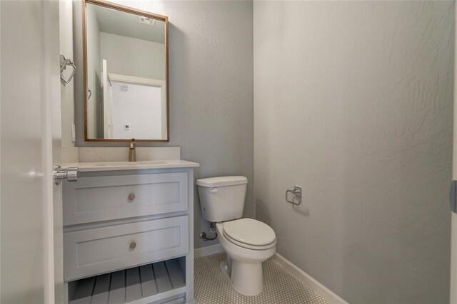 bathroom with tile patterned flooring, vanity, and toilet