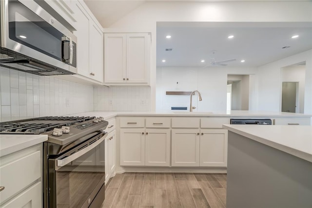 kitchen with white cabinets, appliances with stainless steel finishes, ceiling fan, and sink